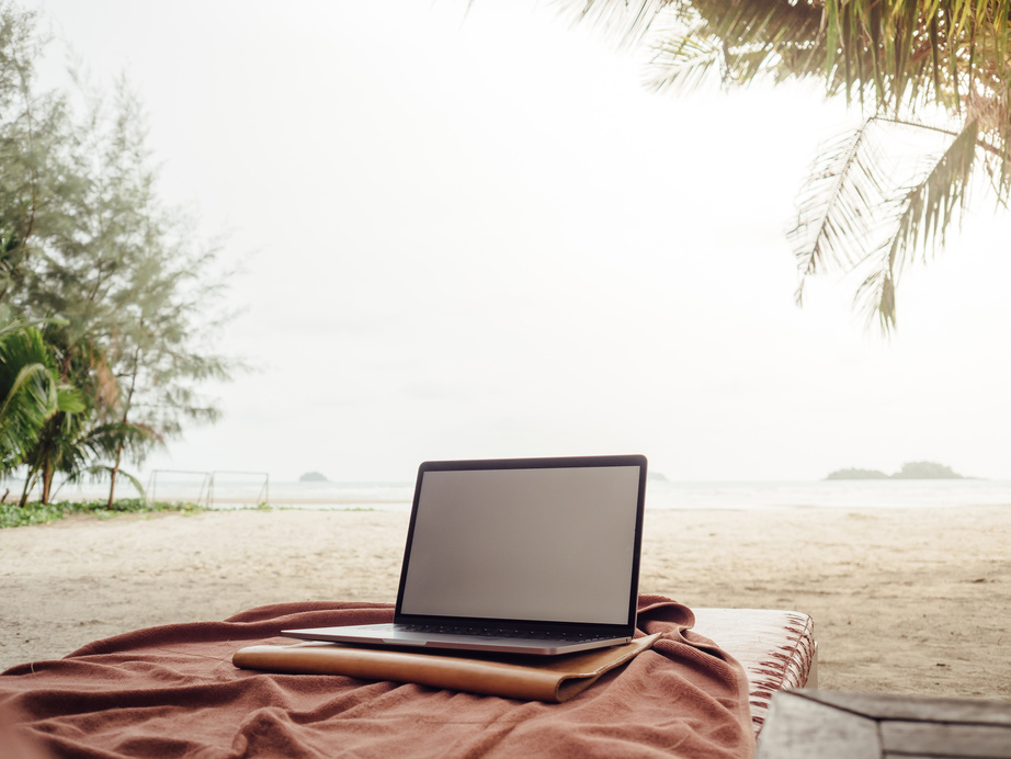 Work with laptop while on vacation at tropical beach.